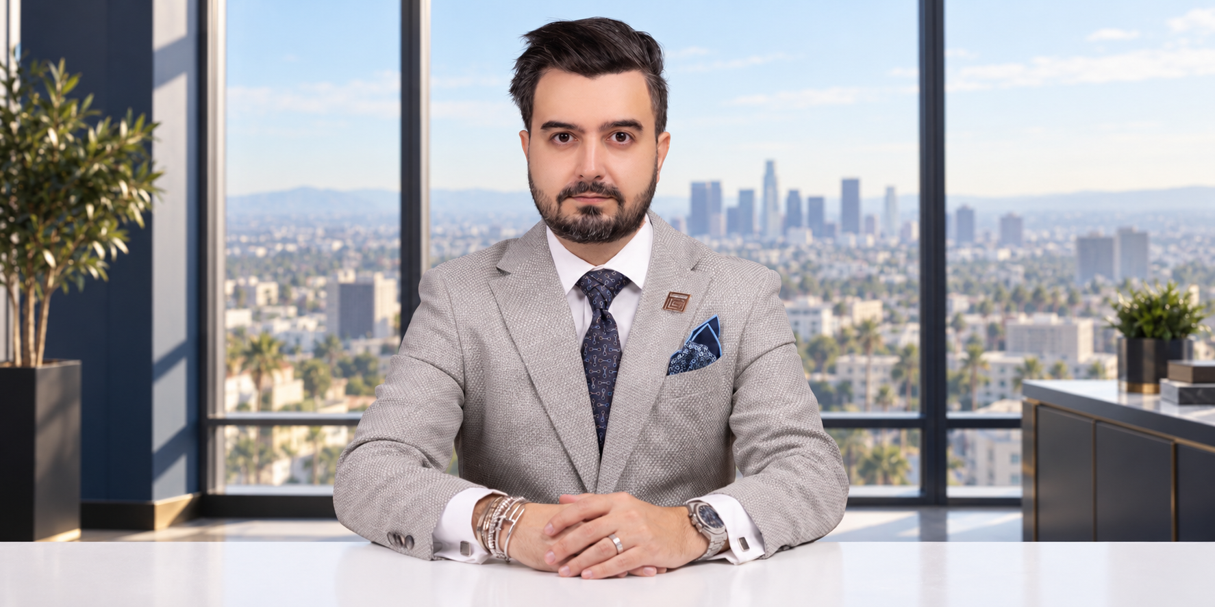 Attorney Alipour at his desk with an illustrative high-rise office backdrop